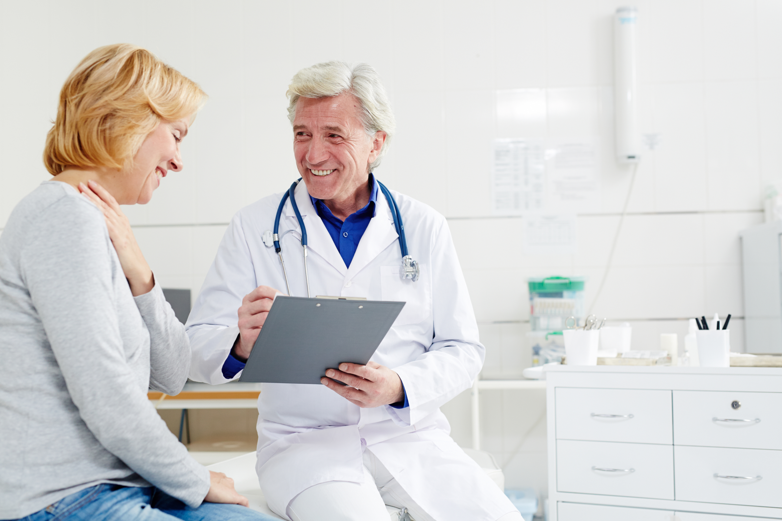 Doctor sits with patient that has chest pain.