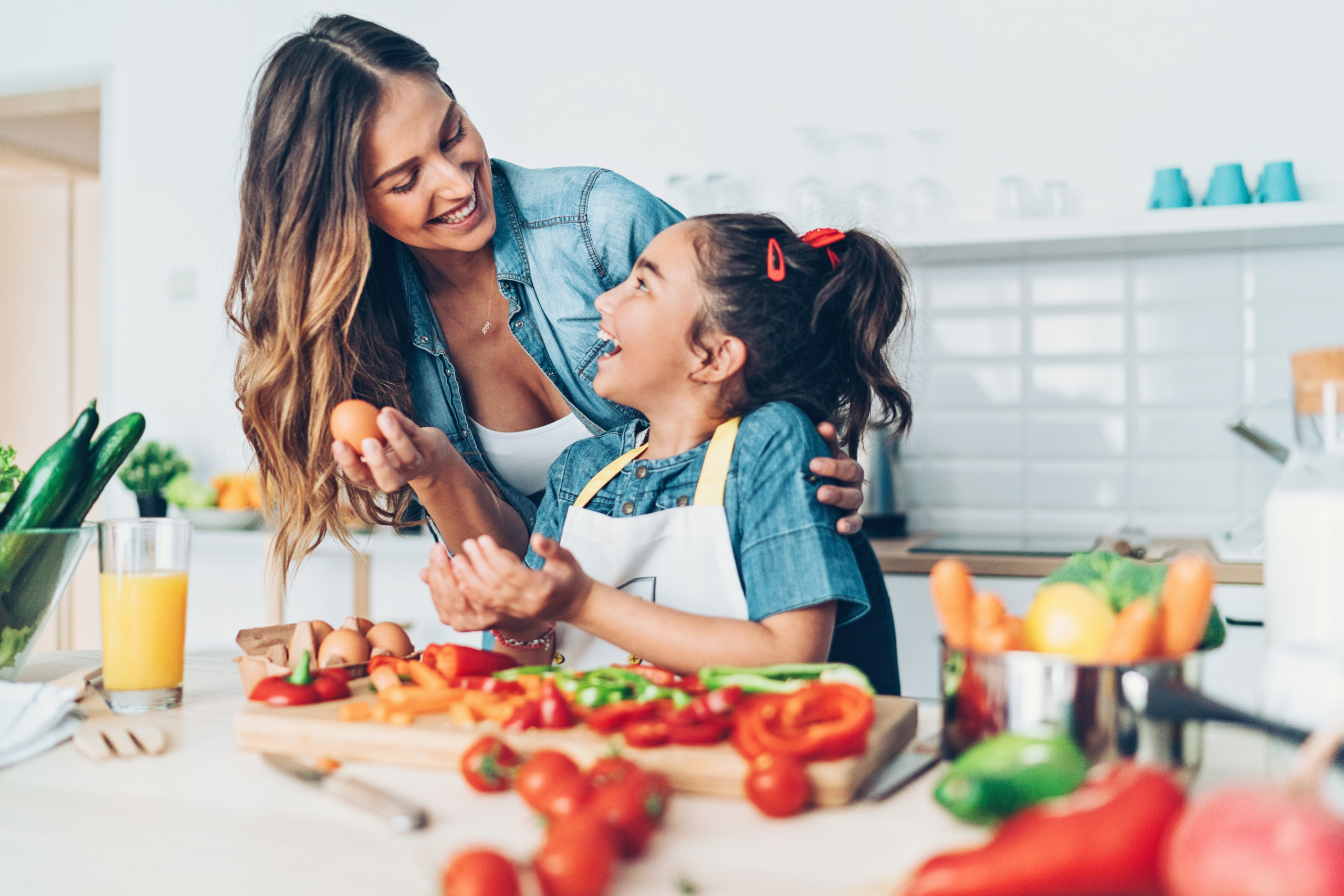 Mother an daughter packing a healthy meal with food on the kitchen counter