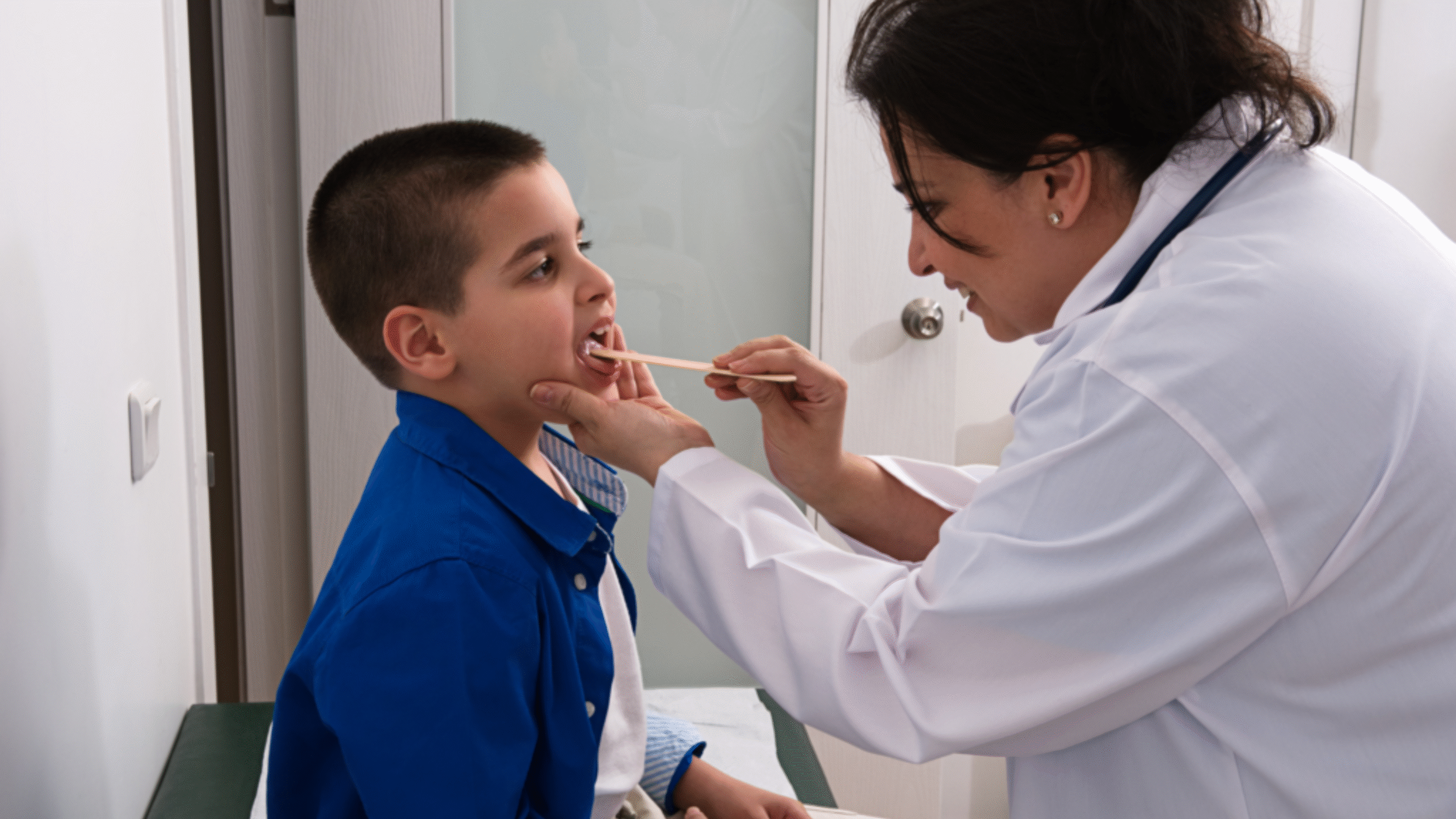 doctor looks into young patients throat in the ER
