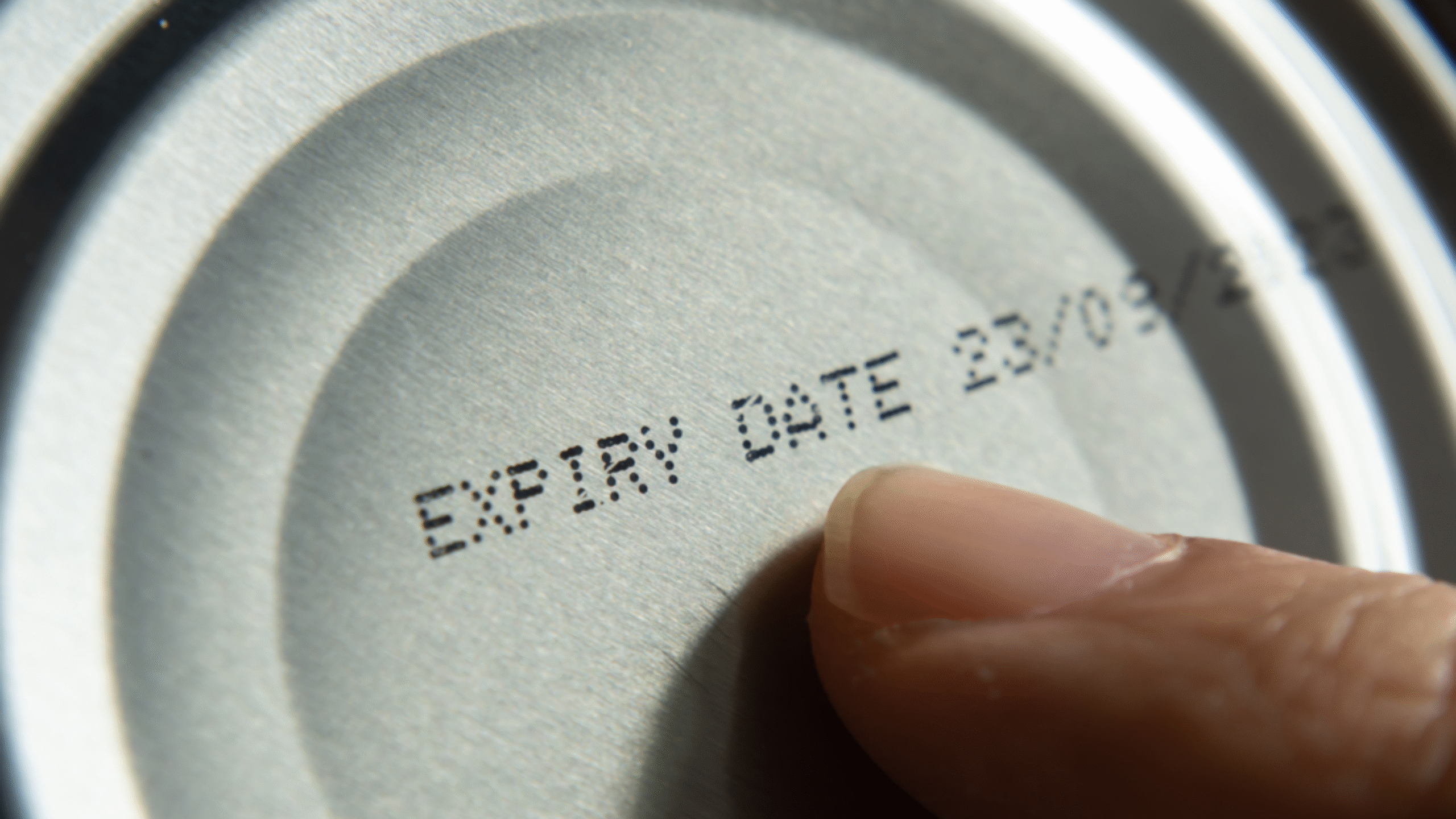 pointing to expiration date on can