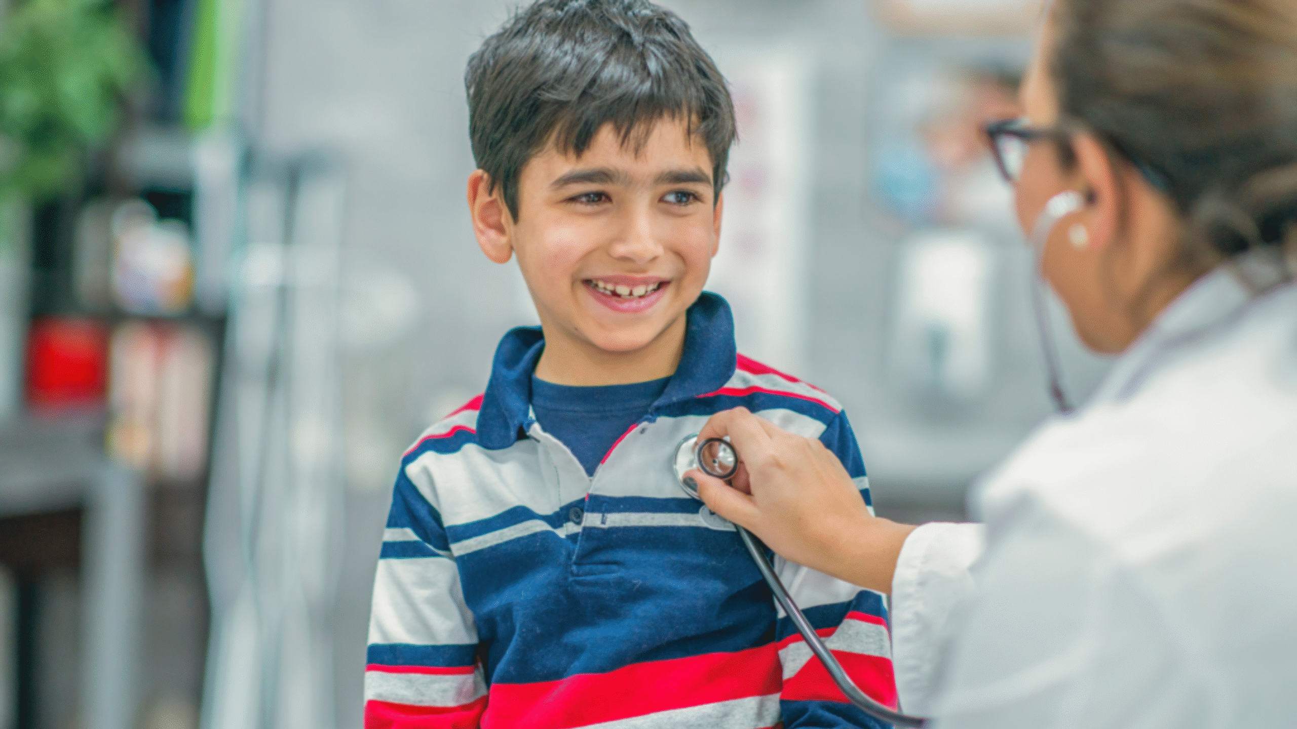 child speaks with physician as she listens to his heartbeat