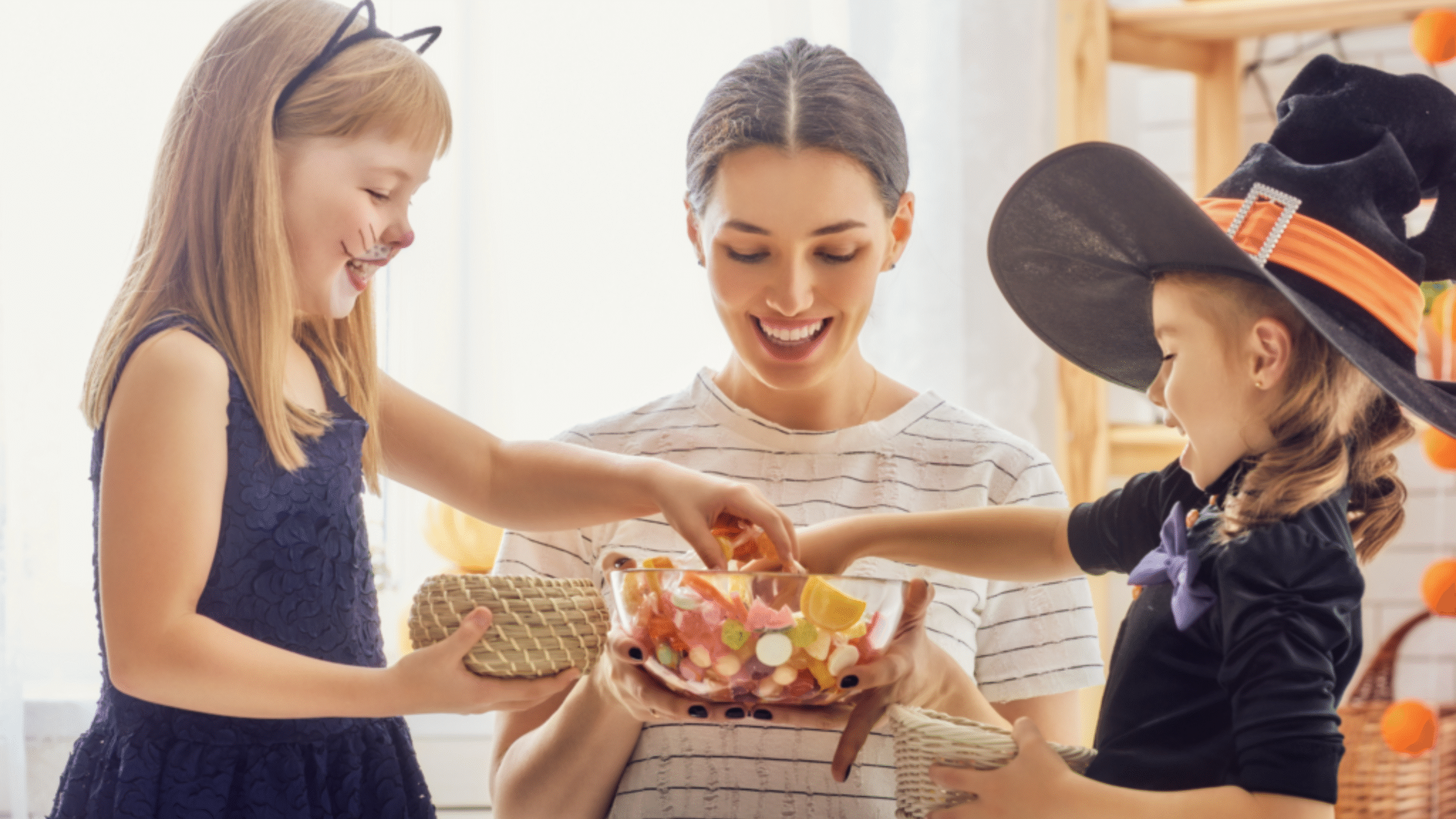 mother looks through Halloween candy bowl with kids