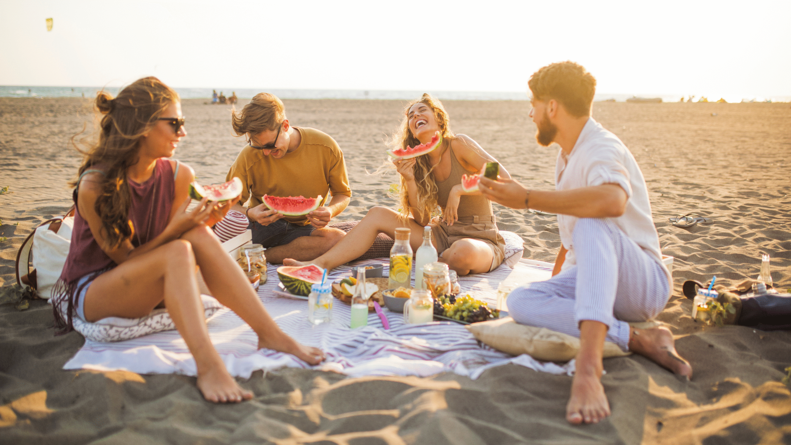 friends gather on the beach for a picnic